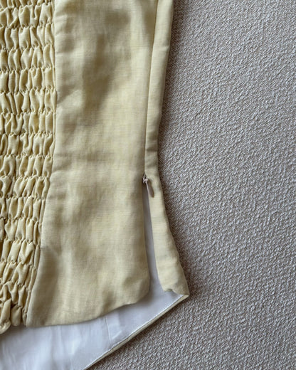 Corset top in light yellow, with invisible side zipper closure. 